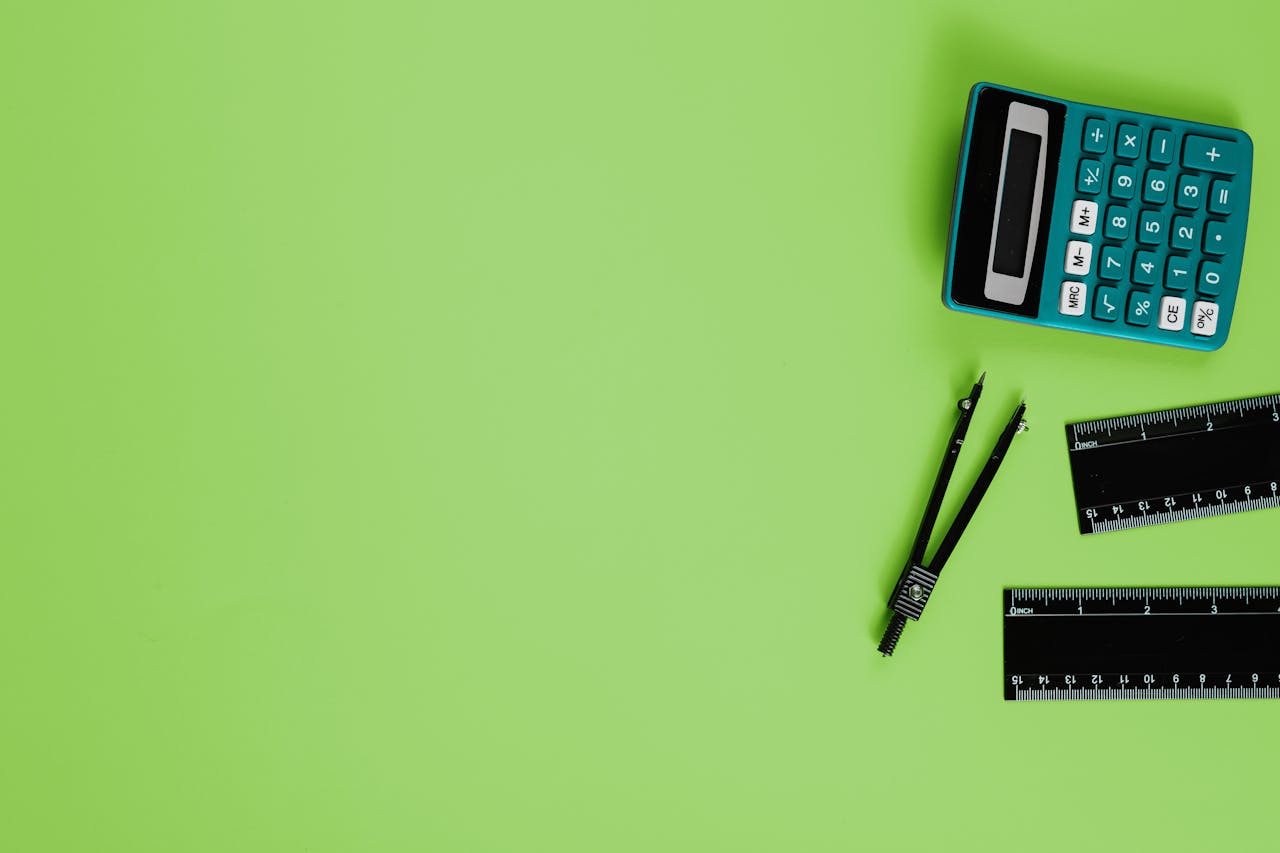 Calculator and drawing tools on a vibrant green background with ample copy space.